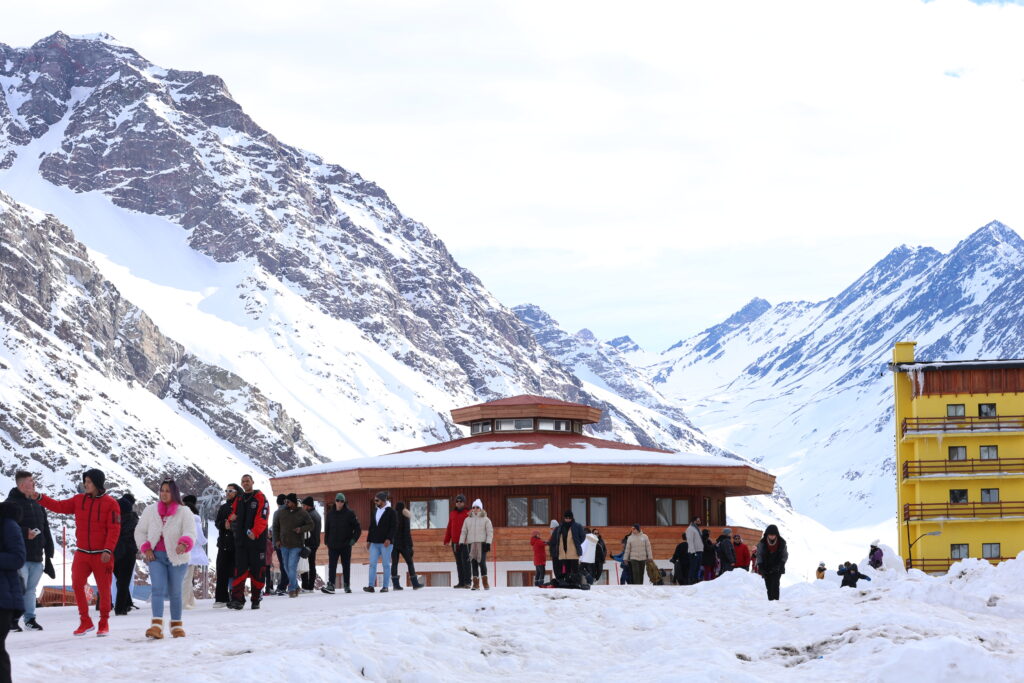 Imagem do centro de Ski Portillo na temporada de inverno, acesso do estacionamento com pessoas.